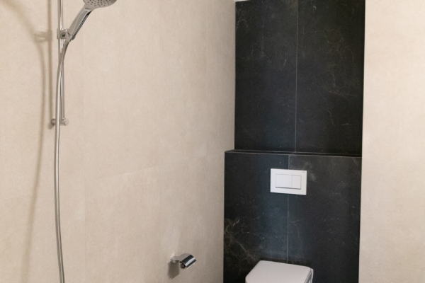 Une salle de Bains après rénovation a Pully près de Lausanne, baignoire et toilette. Carrelage noire et beige