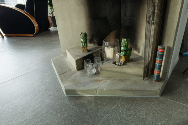 Découpe d'un carrelage autours d'une cheminée en pierre. Rénovation à Montreux, Suisse.