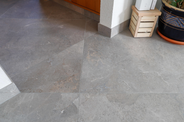 Gros plan sur carrelage gris imitation pierre dans un maison rénovée à Epalinges