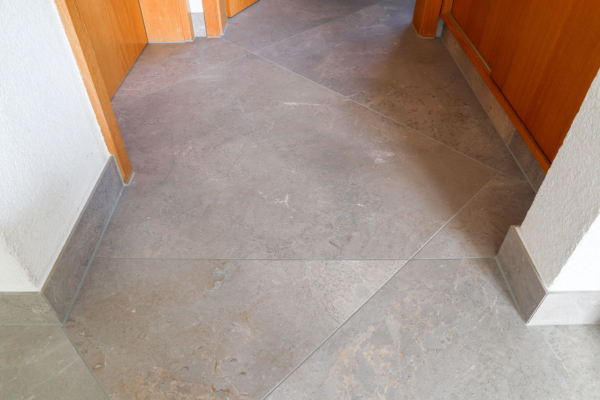 Détail de carrelage gris imitation pierre dans un maison rénovée à Epalinges