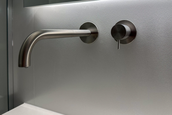 Robinet en acier inoxydable moderne devant un mur en carrelage Iris Ceramica Luce gris clair, détails de haute qualité, salle de bains à Nyon