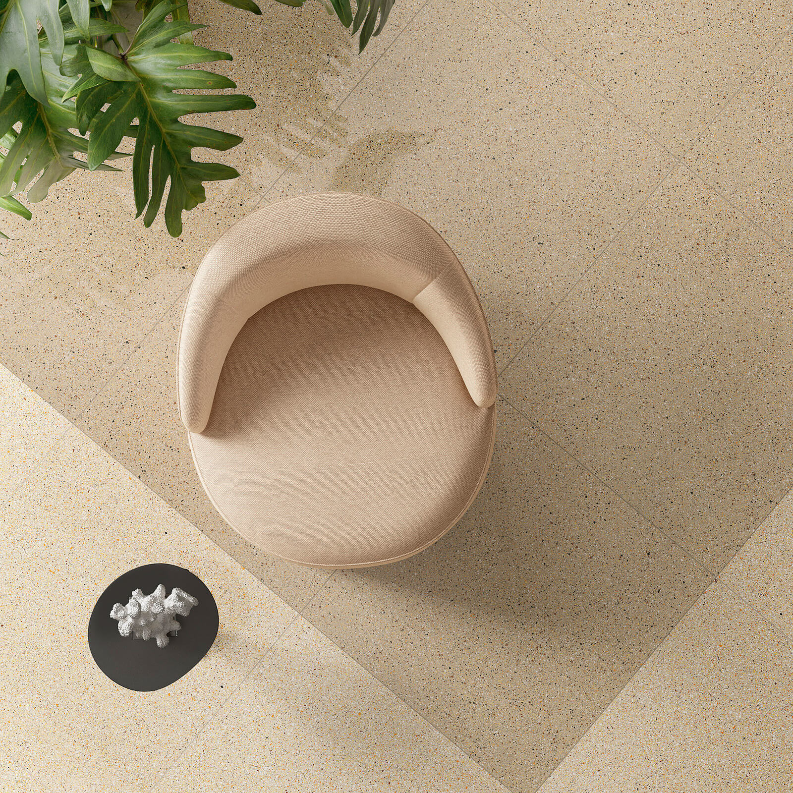 Il Veneziano 4 Chaise moderne minimaliste en tissu beige sur des carreaux de sol mouchetés beige de la collection Il Veneziano, entourée de plantes d'intérieur luxuriantes.