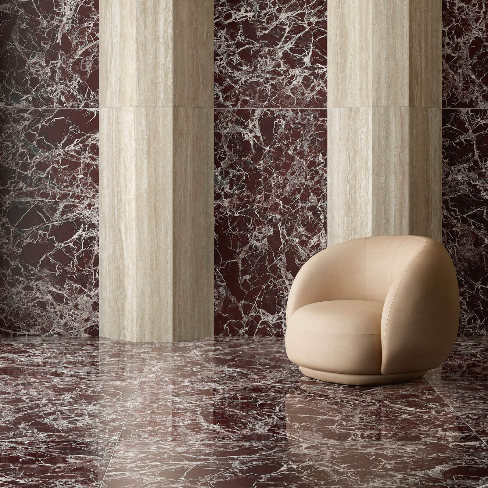 Marmi Maximum Lepanto Rubino 3 Espace de détente dans un hôtel haut de gamme avec canapé beige rond, placé sur un sol en marbre Marmi Maximum Lepantino Rubino, entouré de colonnes en marbre beige.