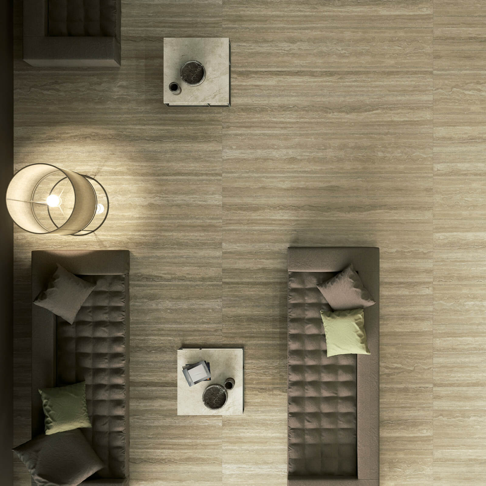 Marmi Maximum Travertino 2 Vue aérienne d'un salon moderne avec des canapés rembourrés gris disposés autour de petites tables basses. Le sol en carrelage imitation marbre Marmi Maximum Travertino beige est éclairé par une grande lampe suspendue, ajoutant de la chaleur à l'espace.