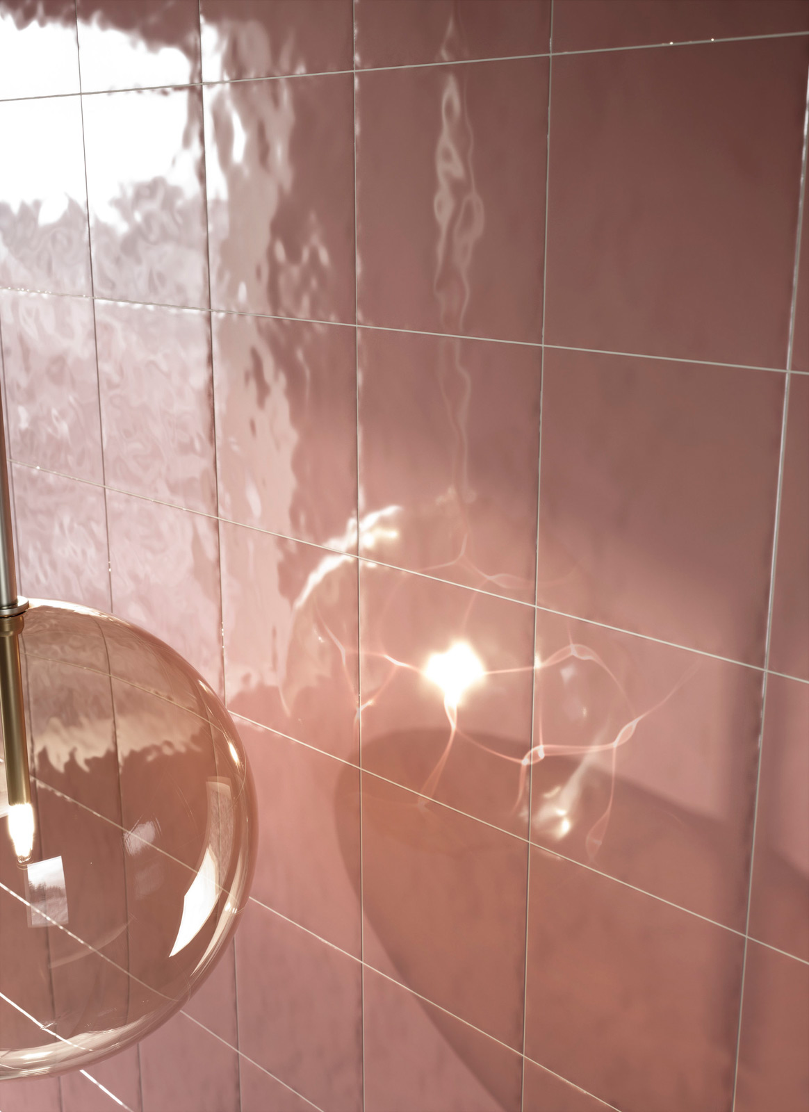 Bottega d'Arte TerreLucide 4 gros plan d'un mur de salle de bain avec des carreaux de faïence Bottega D'arte TerraLucide rose brillant, reflet de la lumière naturelle, lampe suspendue en verre transparent.